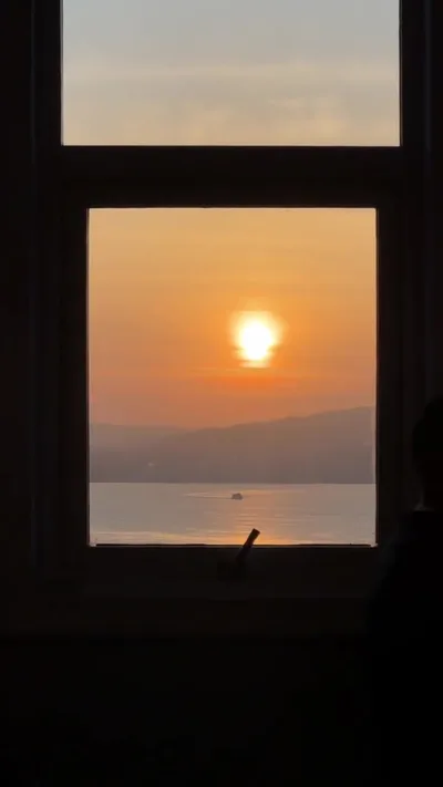 Puesta de sol sobre la ría desde una ventana del bar